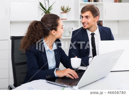 portrait of business man and woman colleagues chatting about work in office 46608780