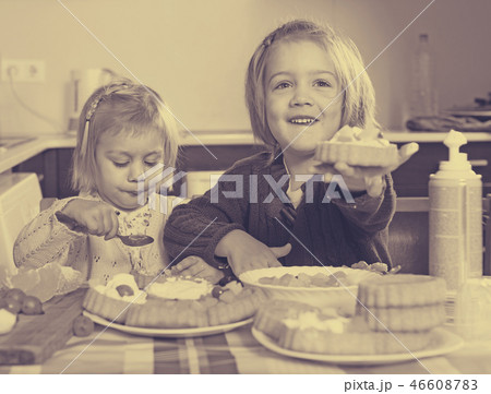 Two little girls with cream desserts 46608783