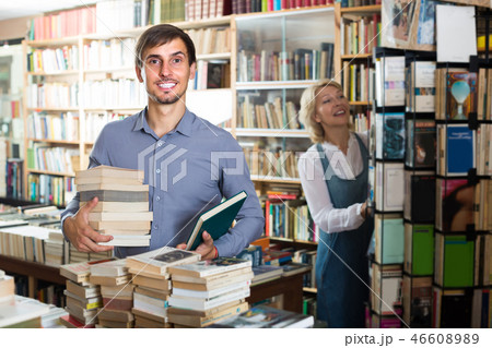 man with pile of book in book store. man with pile of book in book store. 46608989