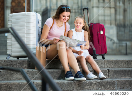 Smiling woman with daughter relaxing on old cathedral steps Smiling woman with daughter relaxing on old cathedral steps 46609020
