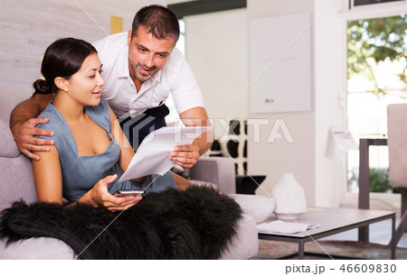 Delighted couple reading papers Delighted couple reading papers 46609830