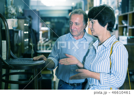 Mature couple is choosing the antique armchair 46610461