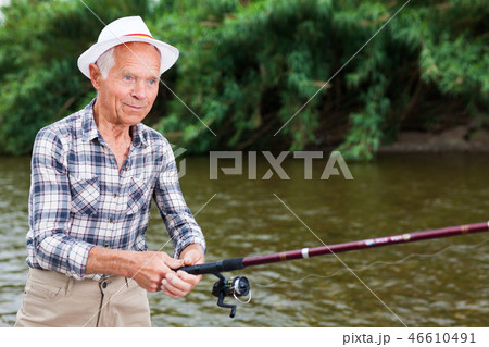 Mature man angling at riverside 46610491