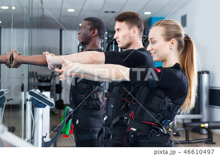 Athletic young people during functional workout with electric muscle stimulation in fitness gym Athletic young people during functional workout with electric muscle stimulation in fitness gym 46610497