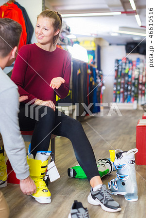 male is helping woman to trying on ski boots male is helping woman to trying on ski boots 46610516