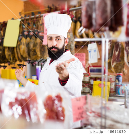 Male shop assistant demonstrating meat Male shop assistant demonstrating meat 46611030