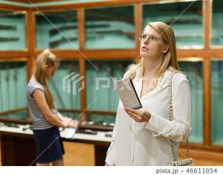 Woman holding guidebook in museum of art, girl on background 46611054