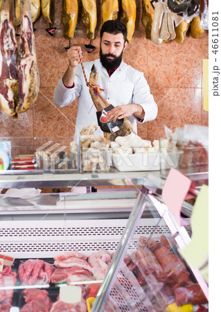 Handsome male seller showing jamon Handsome male seller showing jamon 46611081