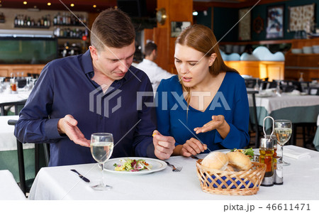 Couple demonstrating dissatisfaction in restaurant Couple demonstrating dissatisfaction in restaurant 46611471