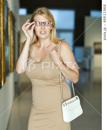 Woman trying to see picture Woman trying to see picture 46611968