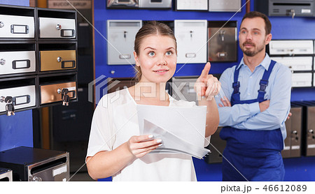 Worker helping woman choosing mailbox 46612089