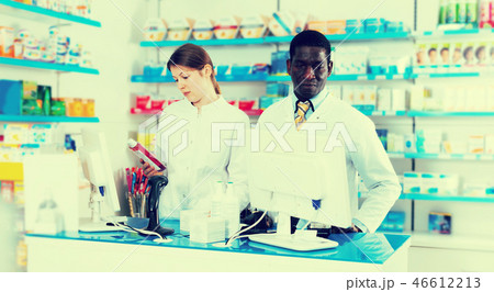 Two pharmacists working behind counter Two pharmacists working behind counter 46612213