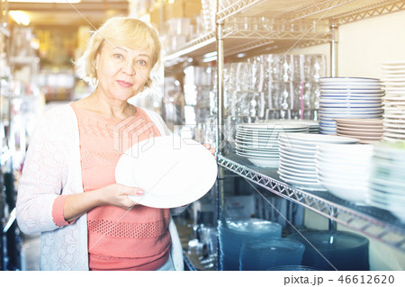female buyer with clay plates in the tableware store 46612620