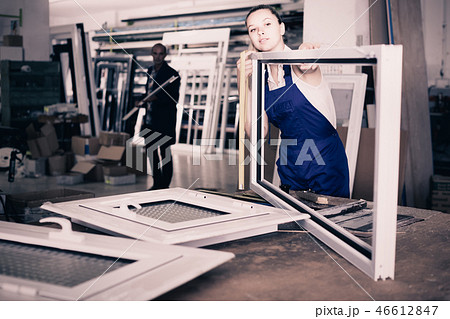 female worker measuring metal-plastic window frame in workshop female worker measuring metal-plastic window frame in workshop 46612847