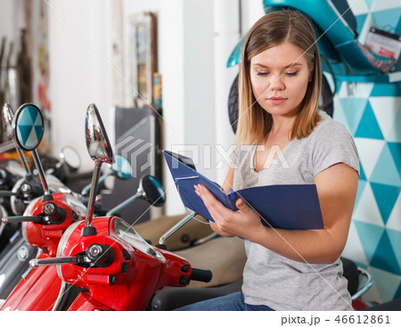 Woman is shopping and choosing new motobike 46612861