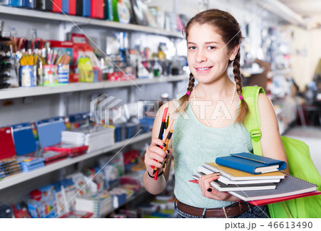 teenager buying different products in stationery shop 46613490