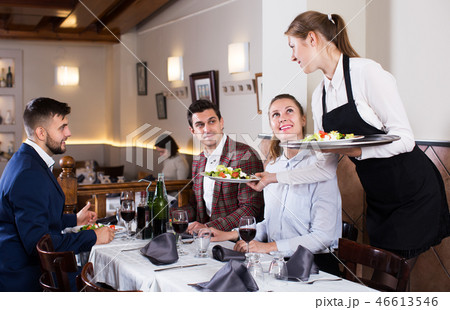 Waitress serving meals to company Waitress serving meals to company 46613546