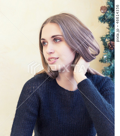 A beautiful young woman in pullover on background of Christmas lights 46614356