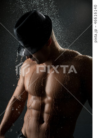 Young muscular man in shower in the dark 46616140