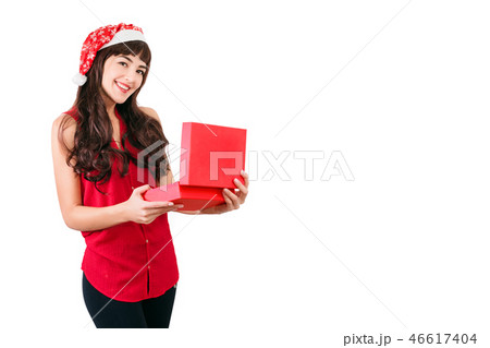 Woman in santa hat opening Christmas gift box isolated on white with copyspace. Happy girl unpacking 46617404
