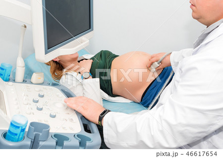 Doctor performing ultrasound scan on pregnant woman in clinic. Expecting of child and diagnosing 46617654