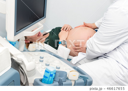 Doctor performing ultrasound scan on pregnant woman in clinic. Expecting of child and diagnosing 46617655