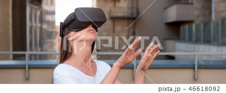 Young woman wearing virtual reality goggles headset, vr box outdoors. Connection, technology, new Young woman wearing virtual reality goggles headset, vr box outdoors. Connection, technology, new 46618092