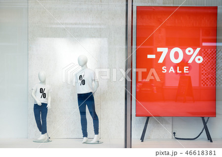 Shopping sale window display with mannequins wearing t-shirts with sign of Sale. Dummies in the Shopping sale window display with mannequins wearing t-shirts with sign of Sale. Dummies in the 46618381