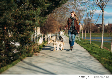 Young lady walking with her dog. Stylish blond hair woman with husky dog Young lady walking with her dog. Stylish blond hair woman with husky dog 46620218