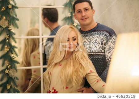 Happy couple stand near the mirror in Christmas time. Holliday spirit 46620519