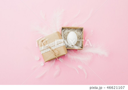 Easter egg in gift box and feather on pastel pink Easter egg in gift box and feather on pastel pink 46621107