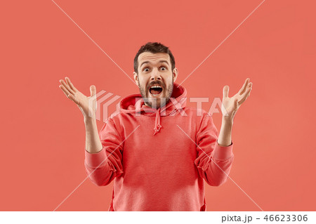 The young attractive man looking suprised isolated on coral 46623306