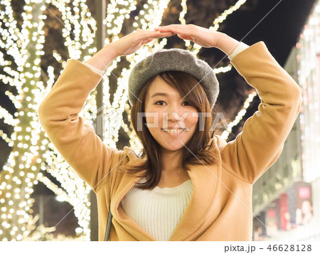 イルミネーションとOKサインをする女性 46628128