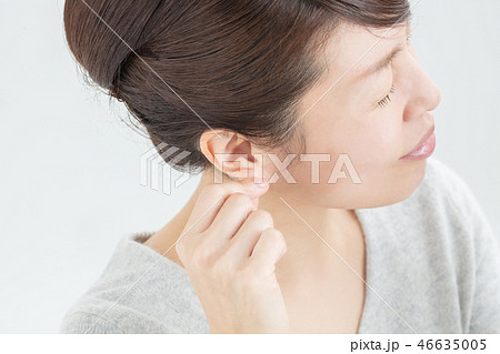 耳を掴む女性の横顔の写真素材