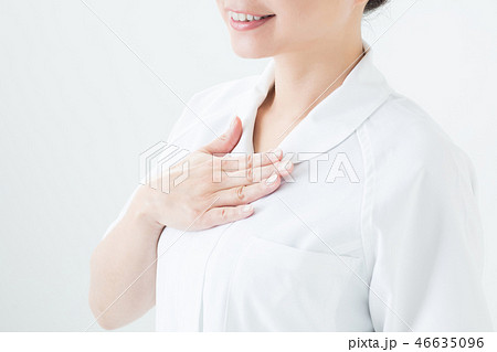 白衣を着て胸に手を置く女性の写真素材
