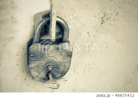 Old rusty lock with a key on a gray background Old rusty lock with a key on a gray background 46635412
