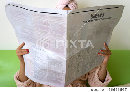 Woman with newspaper is sitting and reading news Woman with newspaper is sitting and reading news 46641647