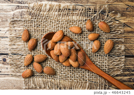 Almonds in wooden spoon on wooden background. Almonds in wooden spoon on wooden background. 46643245