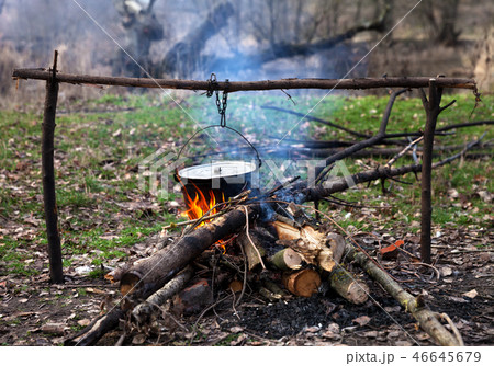 Cooking in old sooty cauldron on campfire 46645679