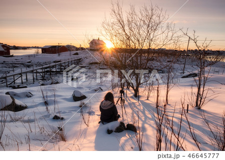 Traveler sitting on snowy with camera on tripod 46645777
