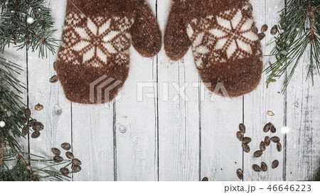 Brown mittens and spruce branches with snow on white wooden background. Holiday banner design 16 in 46646223