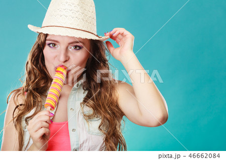 woman in summer hat eating ice pop cream 46662084