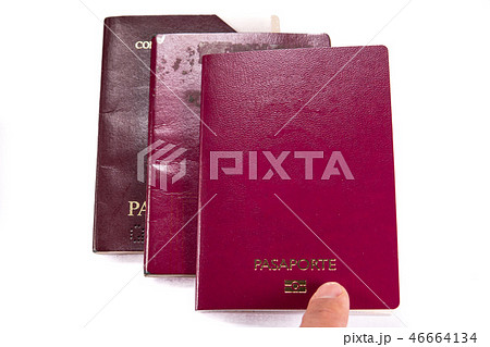 Finger pointint new blank passport over old expired ones 46664134