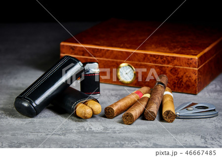 Six Cuban cigars on a stone table with a lighter Six Cuban cigars on a stone table with a lighter 46667485