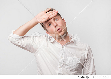 Exhausted european man wipes the sweat of his forehead. 46668335