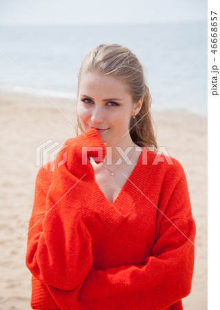 the woman in the Sweater walking on sandy beach, one sea coast the woman in the Sweater walking on sandy beach, one sea coast 46668657