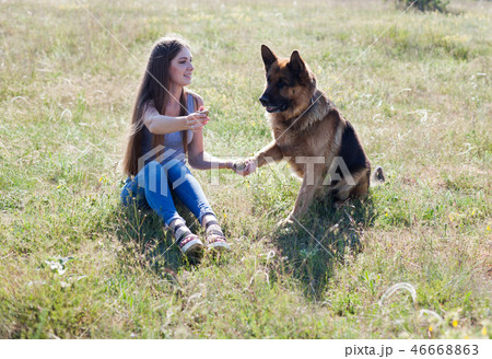 a woman with a child with German Shepherd training 46668863