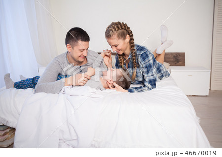 mom dad and young son sleep on the bed in the bedroom 46670019