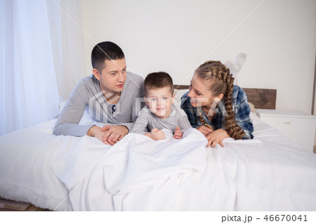mom dad and young son sleep on the bed in the bedroom mom dad and young son sleep on the bed in the bedroom 46670041