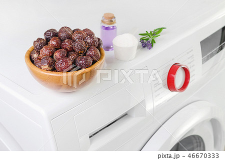 soap nuts in a bowl on the washing machine and lavender oil, detergent powder, selective focus 46670333